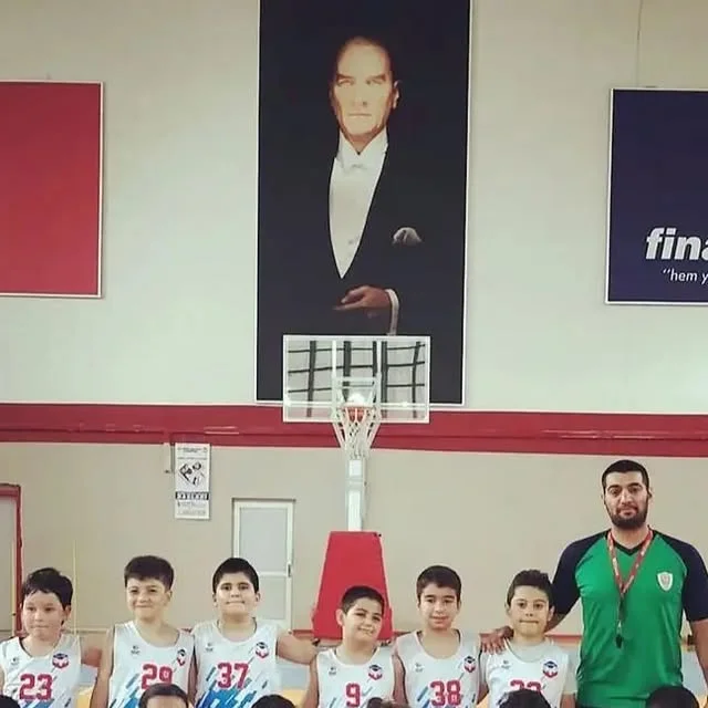 Spor salonunda beyaz numaralı basketbol formalarıyla takım fotoğrafı